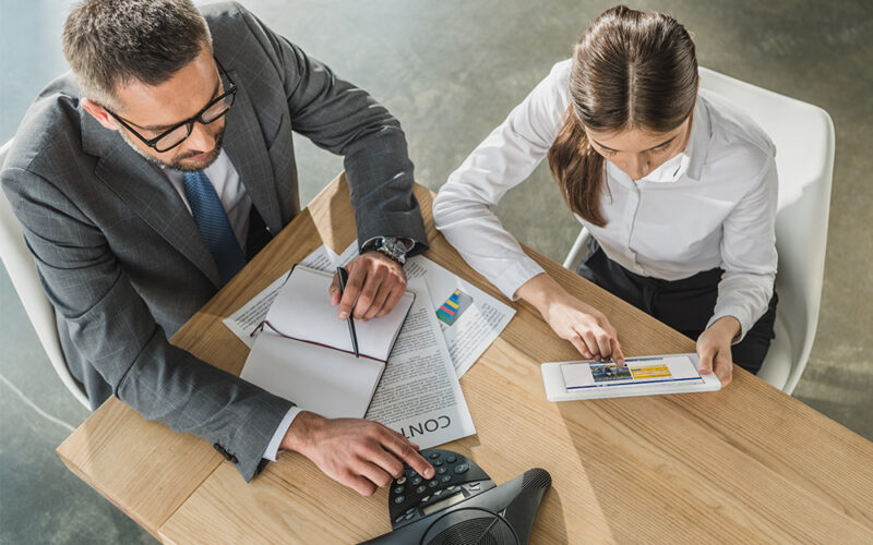 Finance professionals reviewing schedules during a conference call